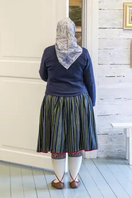 Kihnu naine sinisetriibulise kördiga